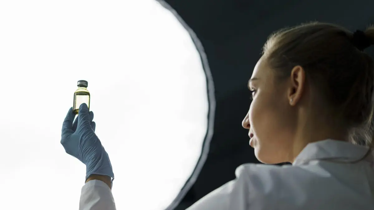 Scienziata che mostra una fiala di cellule staminali.