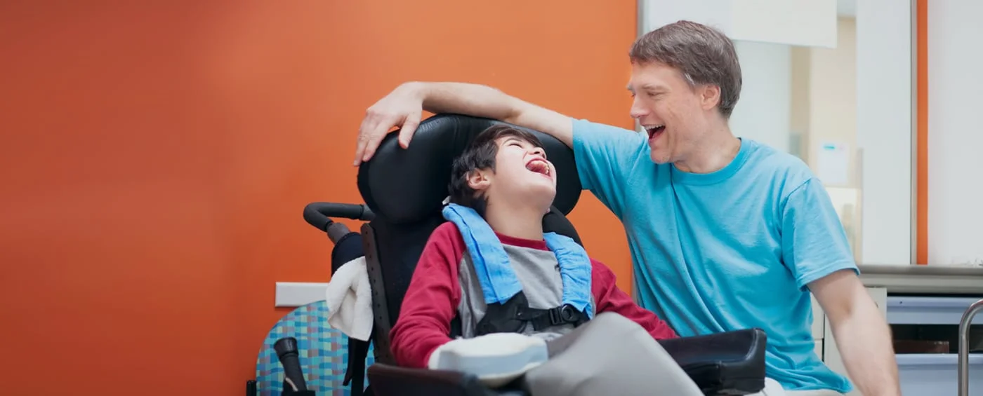 Un bambino che sorride con un genitore durante la riabilitazione con cellule staminali