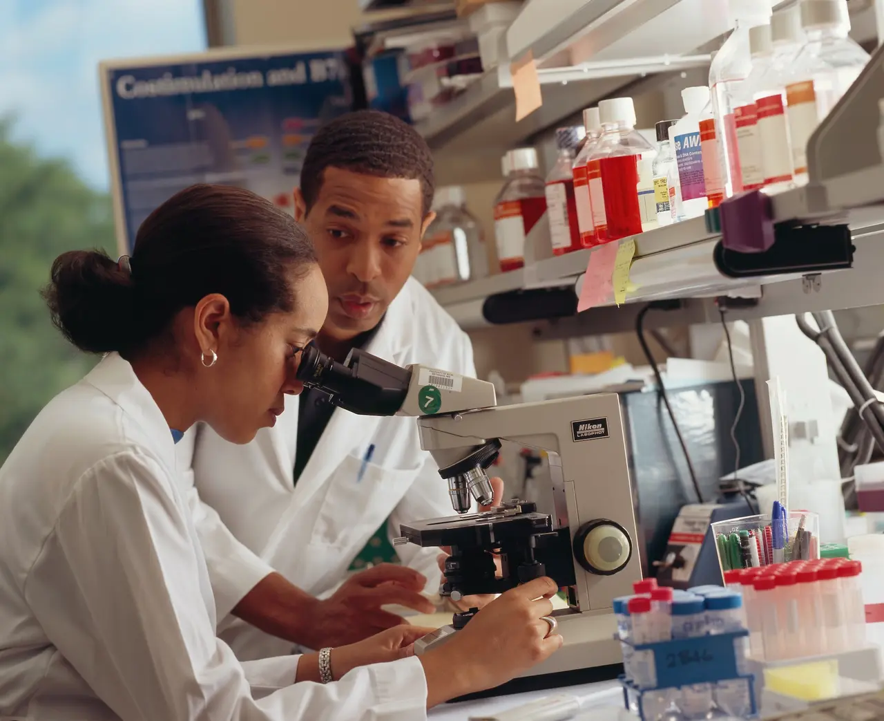 scienziato che esamina cellule staminali al microscopio.